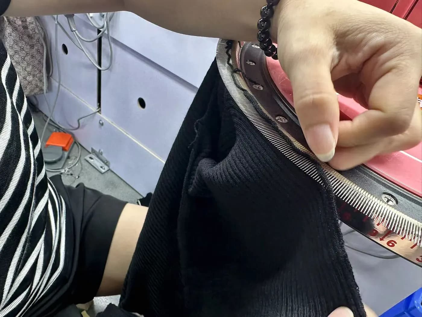 Hands joining knit panels on the linking machine.