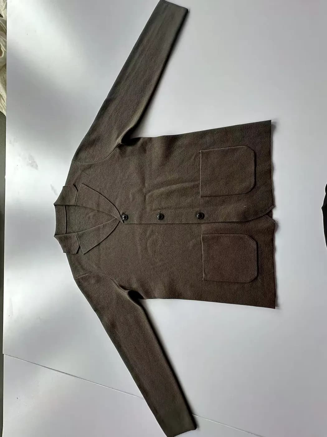 Flat, evenly pressed surface of a finished knit garment