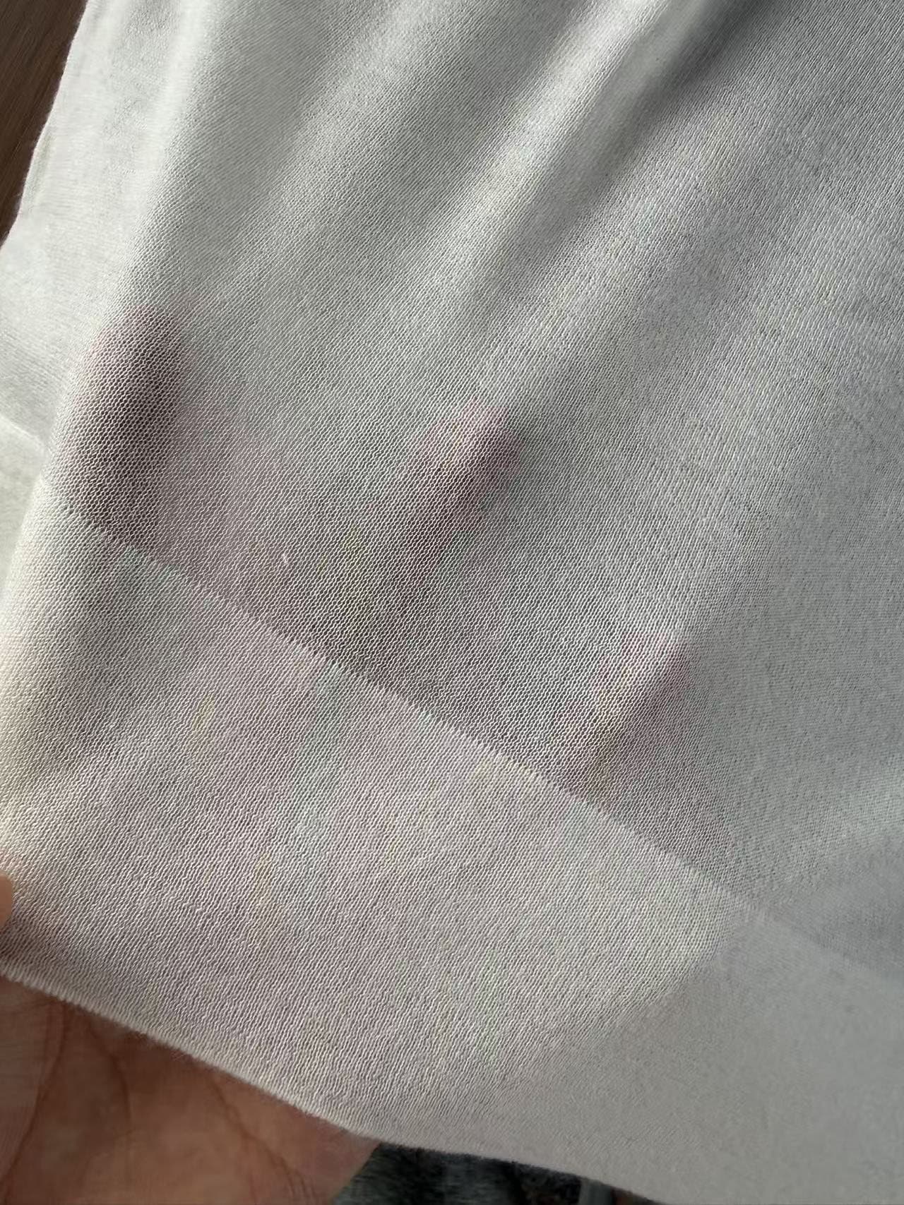 18GG knit held against a hand, the fingers visible through the fabric