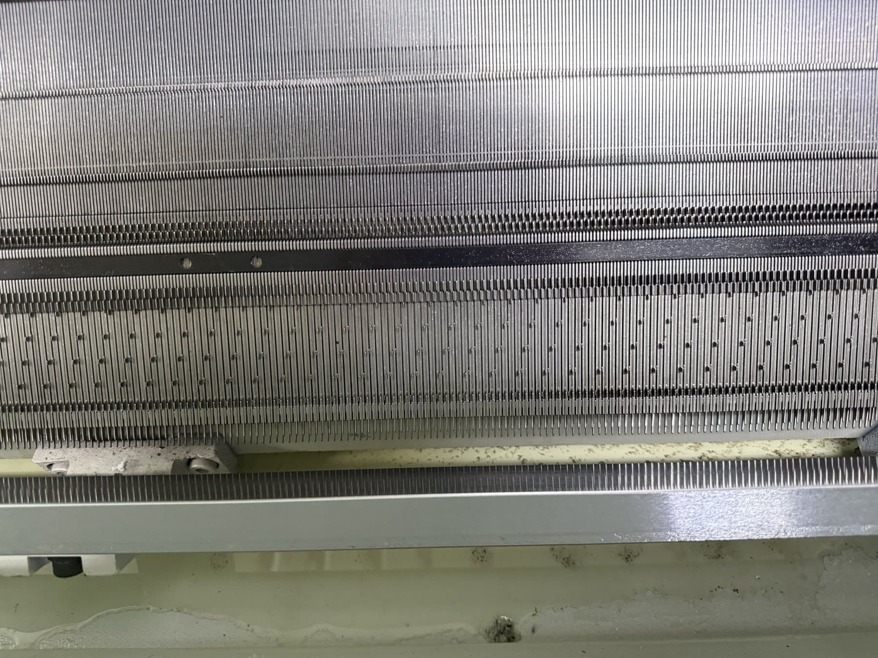 Needle bed detail on a fine-gauge flat knitting machine