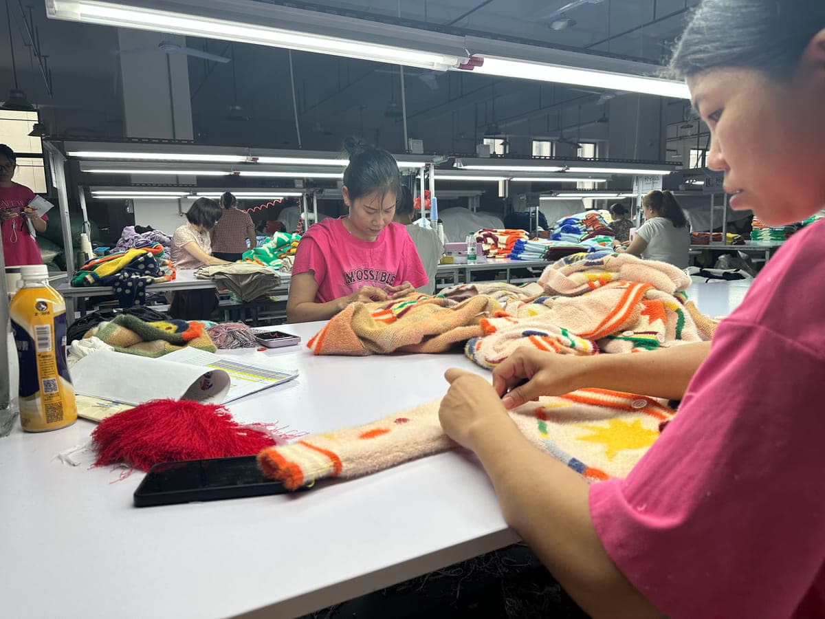 Checking multi-colour knitted panels by hand on our finishing floor in Dongguan - the colour work every alpine motif depends on