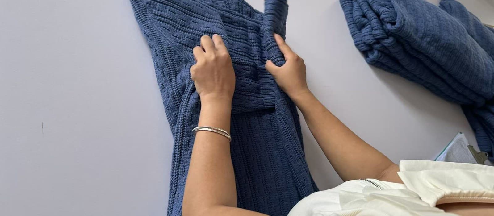 Finished knitwear being inspected and folded to spec at the quality control table