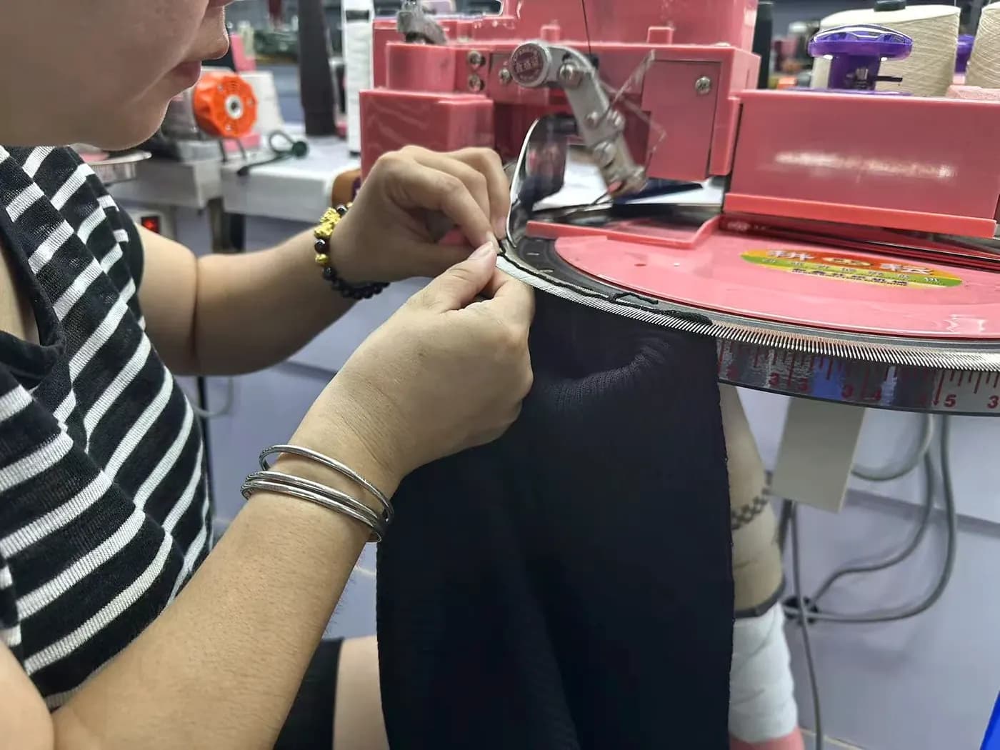 Technician linking knit panels at the linking machine.