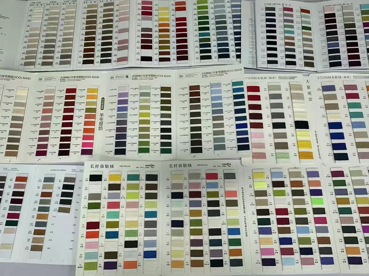 Colour and stitch swatch books open for design reference.
