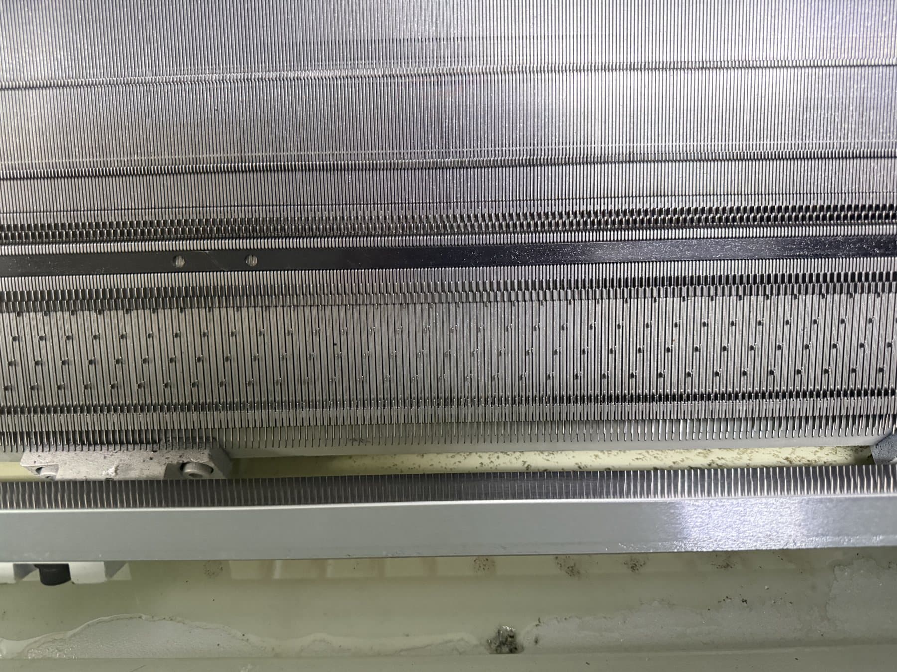 Needle bed detail on a fine-gauge flat knitting machine