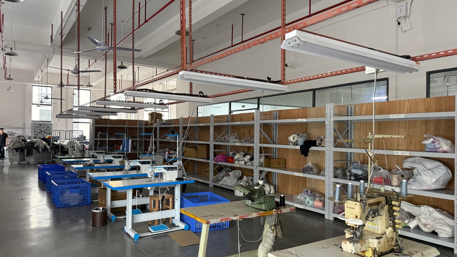 Empty factory aisle with sewing equipment and material storage