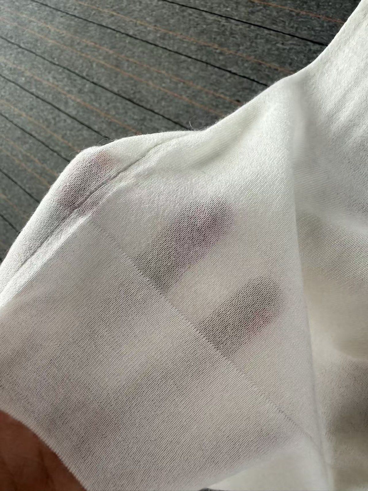 Stitch density of an 18GG knit, the fabric held so the weave reads against the light